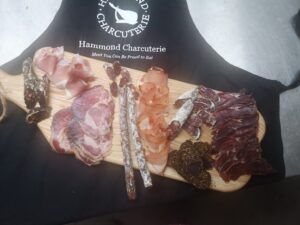 selection of british charcuterie with a hand made board and a special apron