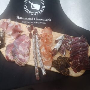 selection of british charcuterie with a hand made board and a special apron